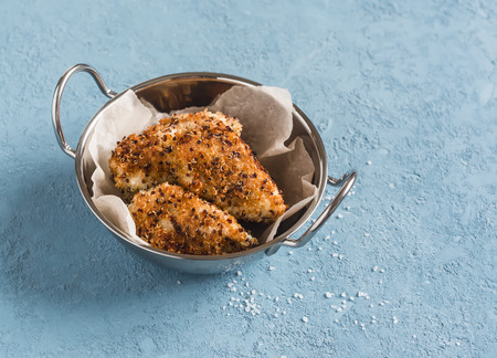 Quinoa crusted chicken in a metal bowl. On a blue background.の写真素材