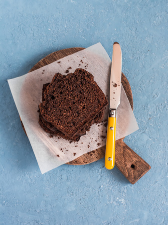 Chocolate banana cake on a rustic cutting board on blue background.の写真素材