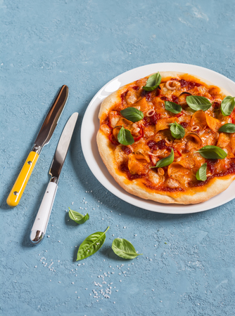 Pumpkin pizza on a blue background, top view.の写真素材