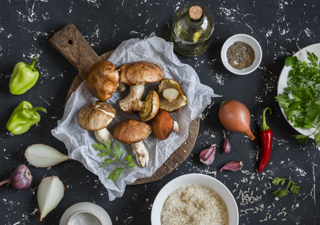 Cooking ingredients. Mushrooms,rice, vegetables and spices. On a dark background, top view. Cooking vegetarian foodの写真素材