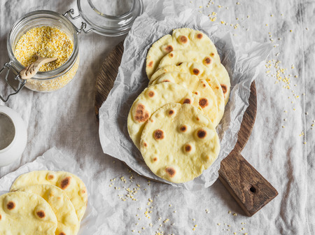 Homemade corn tortilla on a wooden rustic cutting board. On a light background, top viewの写真素材