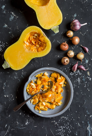 Fresh raw sliced pumpkin on dark background, top viewの写真素材