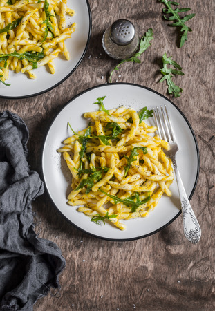 Pasta with pumpkin sauce and arugula. Delicious vegetarian lunch. Top view, flat layの写真素材