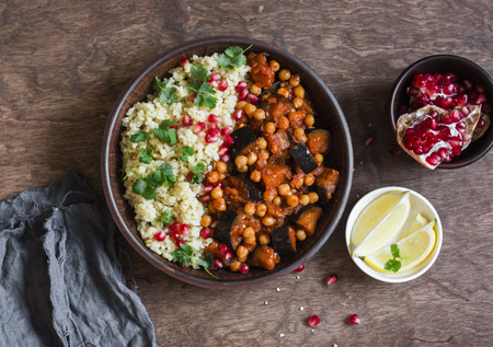 Vegetarian dinner - bulgur and eggplant chickpea stew on a wooden table, top viewの写真素材