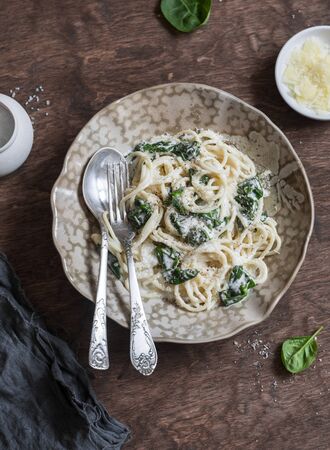Creamy spinach spaghetti on wooden table, top view. Flat layの写真素材