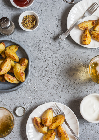 Frame with baked potatoes, beer and sauces. Top view. Free space for textの写真素材