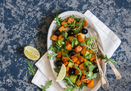 Pumpkin, avocado, olives, and arugula salad. Delicious vegetarian food, top viewの写真素材
