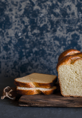 Sliced homemade brioche on a dark background. Front view. Delicious pastries
