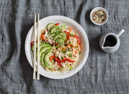 Udon noodles with quick pickled vegetables and avocado on a gray table, top view. Healthy vegetarian food conceptの写真素材