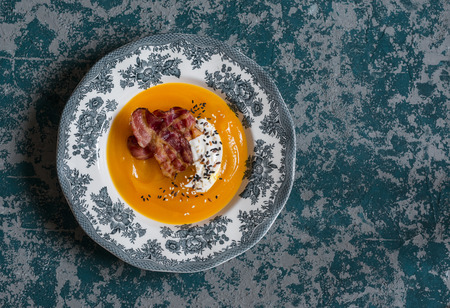 Pumpkin soup with crispy bacon on a dark background, top viewの写真素材