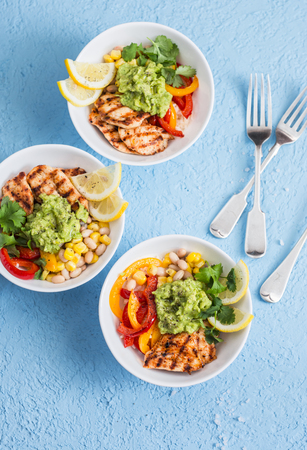 Grilled chicken fajitas bowls on a blue background, top view. Flat layの写真素材