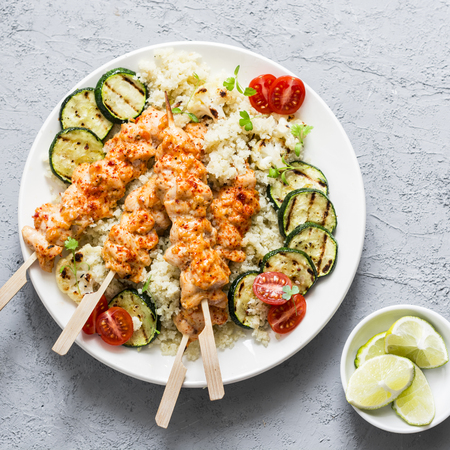 Chicken kebab, cauliflower cous cous and grilled zucchini. Mediterranean style healthy eating on a gray background, top viewの写真素材
