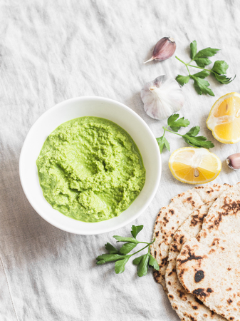 Green avocado dip and gluten free flatbread on a light background, top view. Healthy vegetarian snackの写真素材
