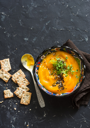 Roasted carrot and turmeric soup on a dark background, top viewの写真素材