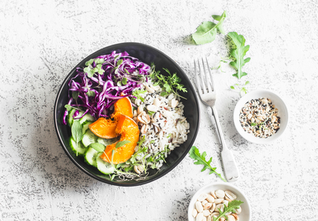 Wild rice, roasted pumpkin, red cabbage buddha bowl. Vegetarian food concept. On a light background, top viewの写真素材