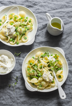 Pasta with green peas, asparagus and fresh ricotta. On a gray background, top view. Healthy delicious foodの写真素材