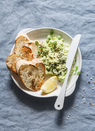 Healthy vegetarian snack - mashed avocado toast bread on blue background, top viewの写真素材