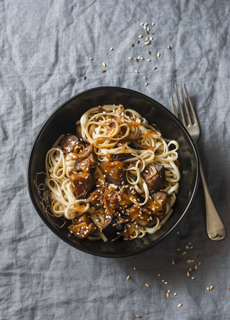 Sweet soy aubergine udon noodles on a gray table, top view. Delicious vegetarian lunch in an asian style. Pasta with spicy eggplantの写真素材