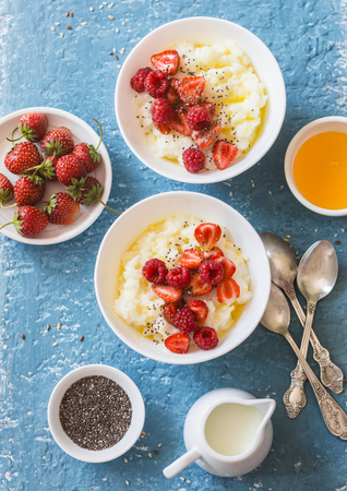 Sweet rice porridge with berries on a light background, top view. Healthy breakfast or dessertの写真素材