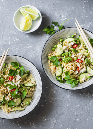 Ramen noodles and pickled cucumber warm salad on a gray background, top view. Asian style foodの写真素材