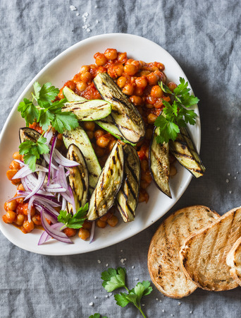 Braised chickpeas in tomato sauce, grilled eggplant and zucchini, grilled bread - a delicious appetizer or snack. Vegetarian foodの写真素材
