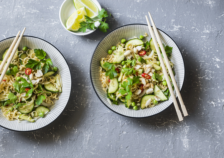 Ramen noodles and pickled cucumber warm salad on a gray background, top view. Asian style foodの写真素材