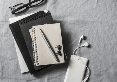 Workplace with business, education accessories. Tablet, phone, headphones, notepad, pen, glasses on grey background, top view. Copy space, flat layの写真素材