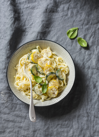 Creamy zucchini pasta with parmesan and basil top of a grey table. Delicious healthy foodの写真素材