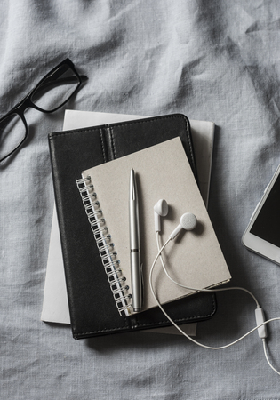 Workplace with business, education accessories. Tablet, phone, headphones, notepad, pen, glasses on grey background, top view. Copy space, flat layの写真素材