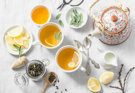 Green tea with lemon, ginger, sage on a light background, top view. Healthy detox drink. Tea ceremonyの写真素材