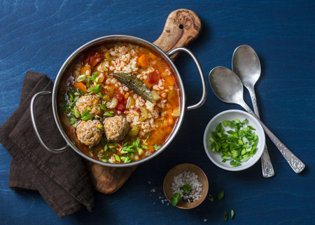Multi grain, meatballs and vegetables soup in a pot on a blue background, top view. Comfort home cooking healthy seasonal food conceptの写真素材
