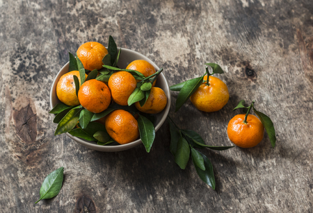 Fresh ripe tangerines in a  bowl on wooden background. Free spaceの写真素材