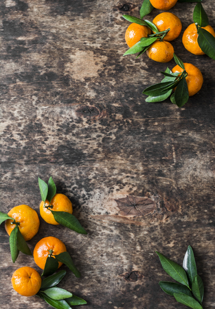 Wooden background with fresh tangerines, top view. Free space for text. Flat layの写真素材