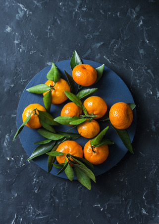 Fresh ripe mandarins on blue background, top view. Free space, flat layの写真素材