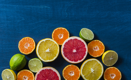 Assortment of citrus fruits on a blue background, top view. Oranges, grapefruit, tangerine, lime, lemon - organic fruits, vegetarian healthy food conceptの写真素材