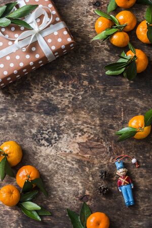 Festive brown wooden background with fresh ripe tangerines and retro gift box with free place for text, top view. Flat layの写真素材