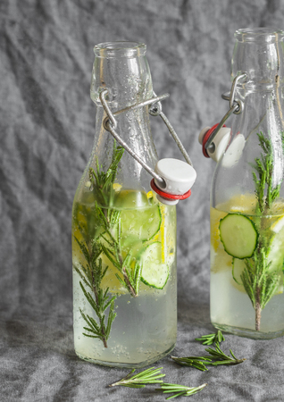Rosemary, lemon, cucumber homemade lemonade in vintage glass bottles on a grey background. Healthy vegetarian drinkの写真素材