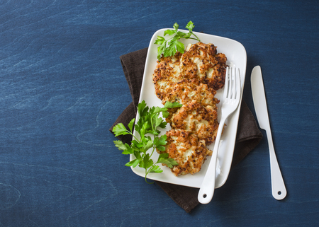 Cauliflower and chicken fritters on a blue background, top view. Delicious appetizer or snackの写真素材