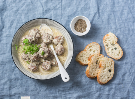 Lamb meatballs in a yogurt sauce - delicious healthy snack in a mediterranean style on a blue background, top viewの写真素材