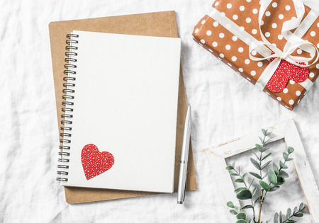 Valentine's day background. Empty blank notebook, gift box, flowers on a white background, top view. Free space for textの写真素材