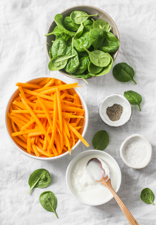 Healthy food ingredients for cooking - slices of pumpkin, spinach, cream and spices on white background, top viewの写真素材