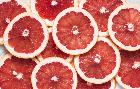 Food background. Cut fresh ripe grapefruit, top view, flat lay. Free space for textの写真素材