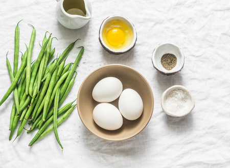 Raw ingredients for cooking breakfast - eggs, green beans, olive oil, spices on a white background, top view. Flat layの写真素材