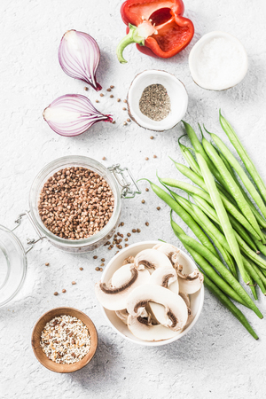 Healthy vegetarian food ingredients for lunch on a light background, top view. Buckwheat, green beans, sweet peppers, mushrooms, red onion - clean eating vegetarian food conceptの写真素材