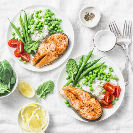 Healthy balanced mediterranean diet lunch - baked salmon, rice, green peas and green beans on a light background, top view. Flat layの写真素材