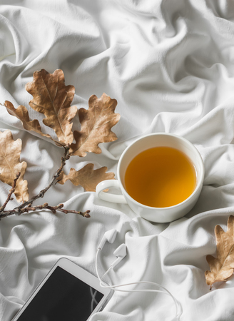 Relax cozy time - cup of green tea, music player headphones in bed. Top view, rest timeの写真素材