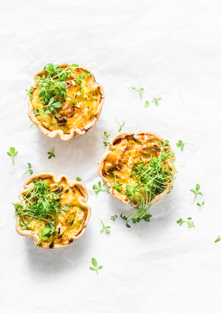 Mini savory pie with chicken, leek, cheese on light background, top view. Delicious appetizer, snack, breakfast, tapasの写真素材