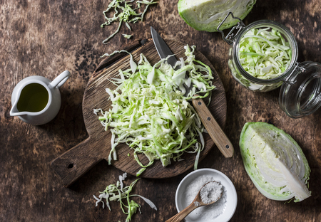 Cut cabbage on wooden chopping board on wooden background, top view. Vegetarian, slimming, diet food concept. Flat layの写真素材