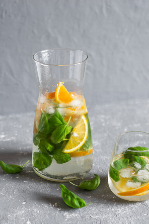 Orange basil infused detox water on a gray background. Vegetarian, dietary, weight loss conceptの写真素材