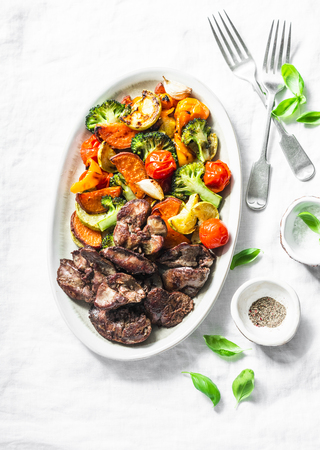 Fried chicken liver and baked seasonal vegetables - delicious healthy lunch on light background, top viewの写真素材